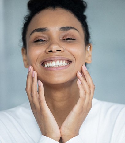 Close-up of woman smiling and holding her hands up