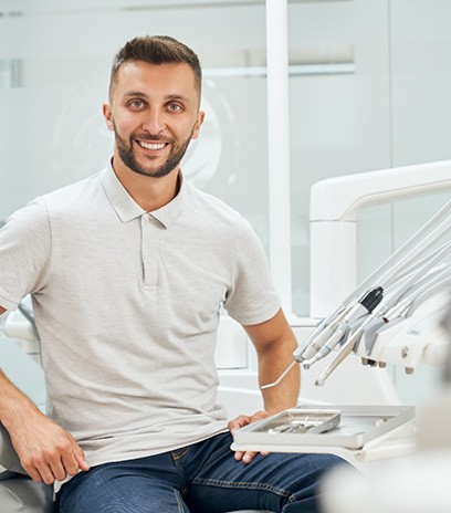 Man sitting up in dental chair and smiling