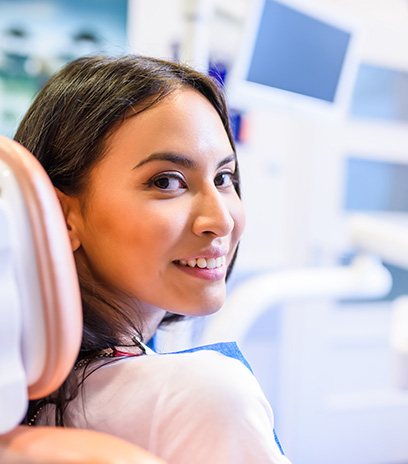 Female dental patient sitting in chair and looking back