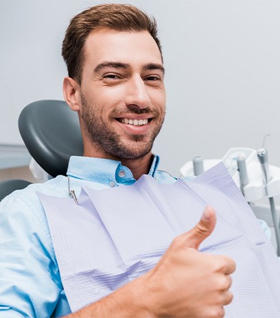 Male dental patient giving a thumbs up