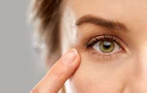 Close-up of woman pointing to her eye