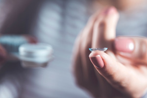 Close-up of contact lens balanced on finger